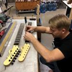 Patrick is dialing in fret height on some spare necks